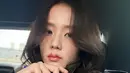 Jisoo memamerkan tas Dior yang ia bawa. Kali ini ia membawa tas Dior model kotak warna hitam dengan lace di bagian depan warna putih motif floral. Dan memiliki keychain Diornya.  [@sooyaaa__]