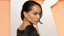 Zoë Kravitz memilih gaun hitam dari Saint Laurent dengan desain unik berupa jaring kristal di bagian belakang, menampilkan siluet punggungnya yang indah sekaligus berani.  [@whowhatwear].